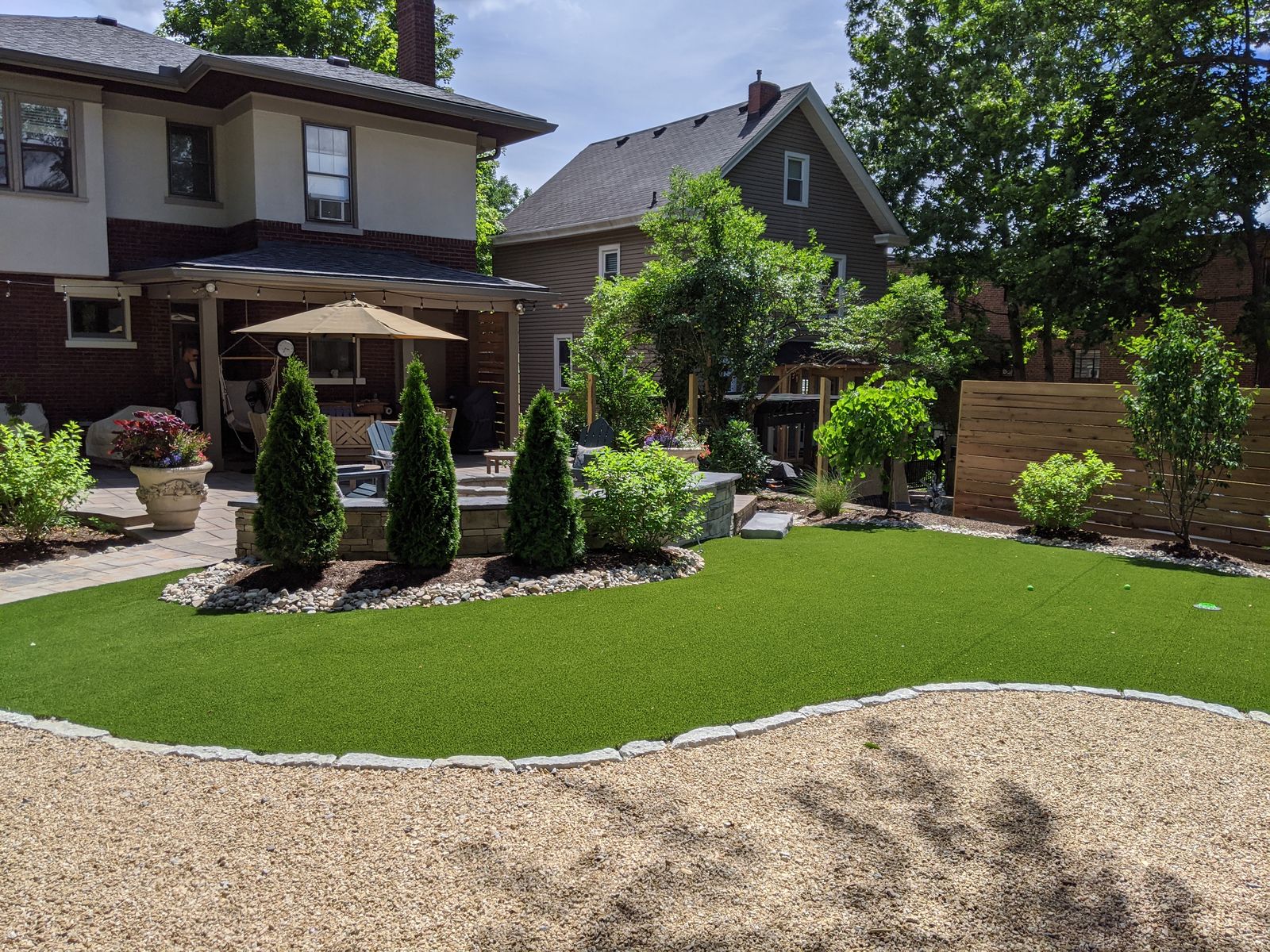 Manicured lawn and paver patio framed by stone seat walls