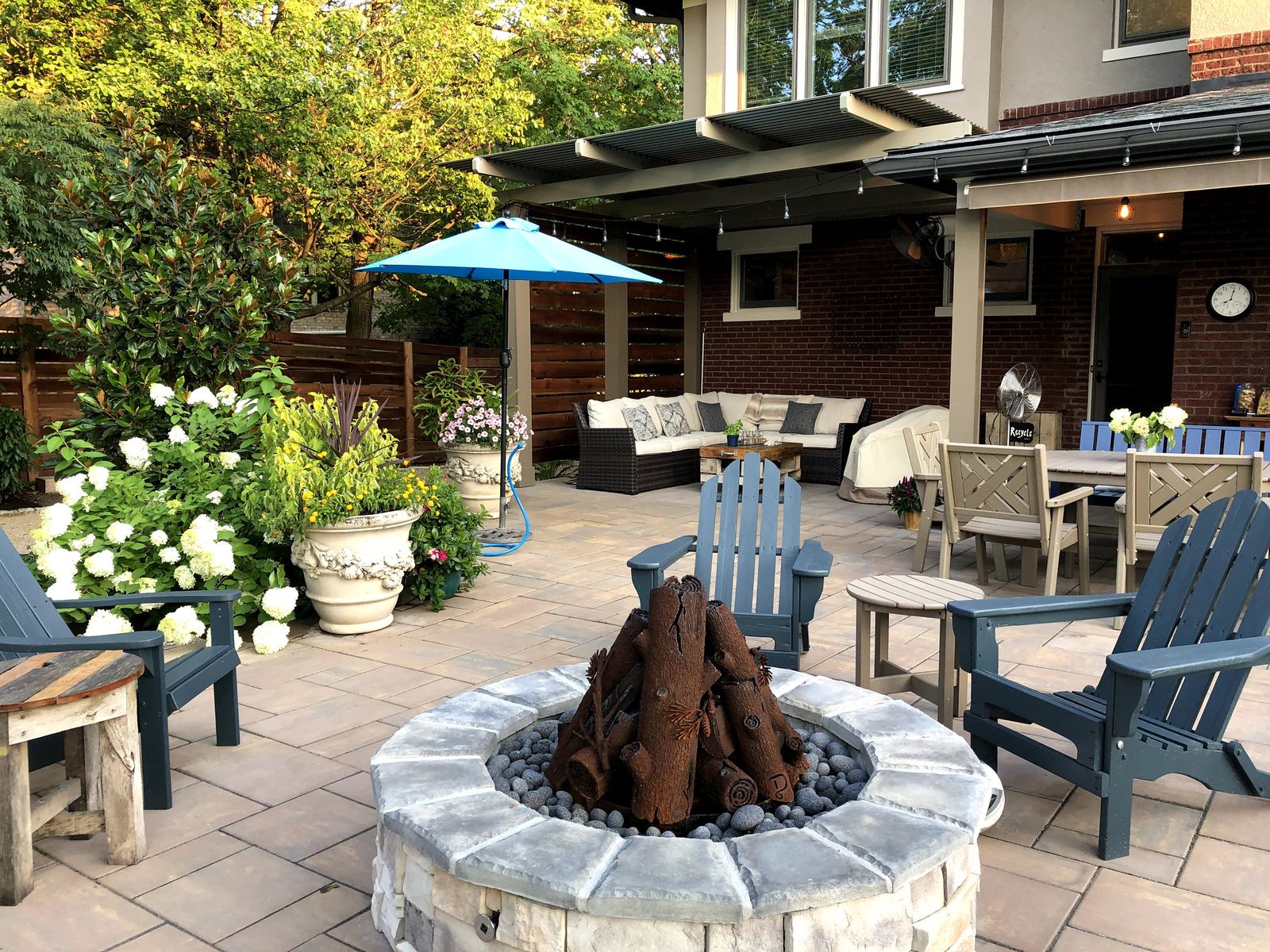 Circular stone fire pit with Adirondack seating on the paver patio