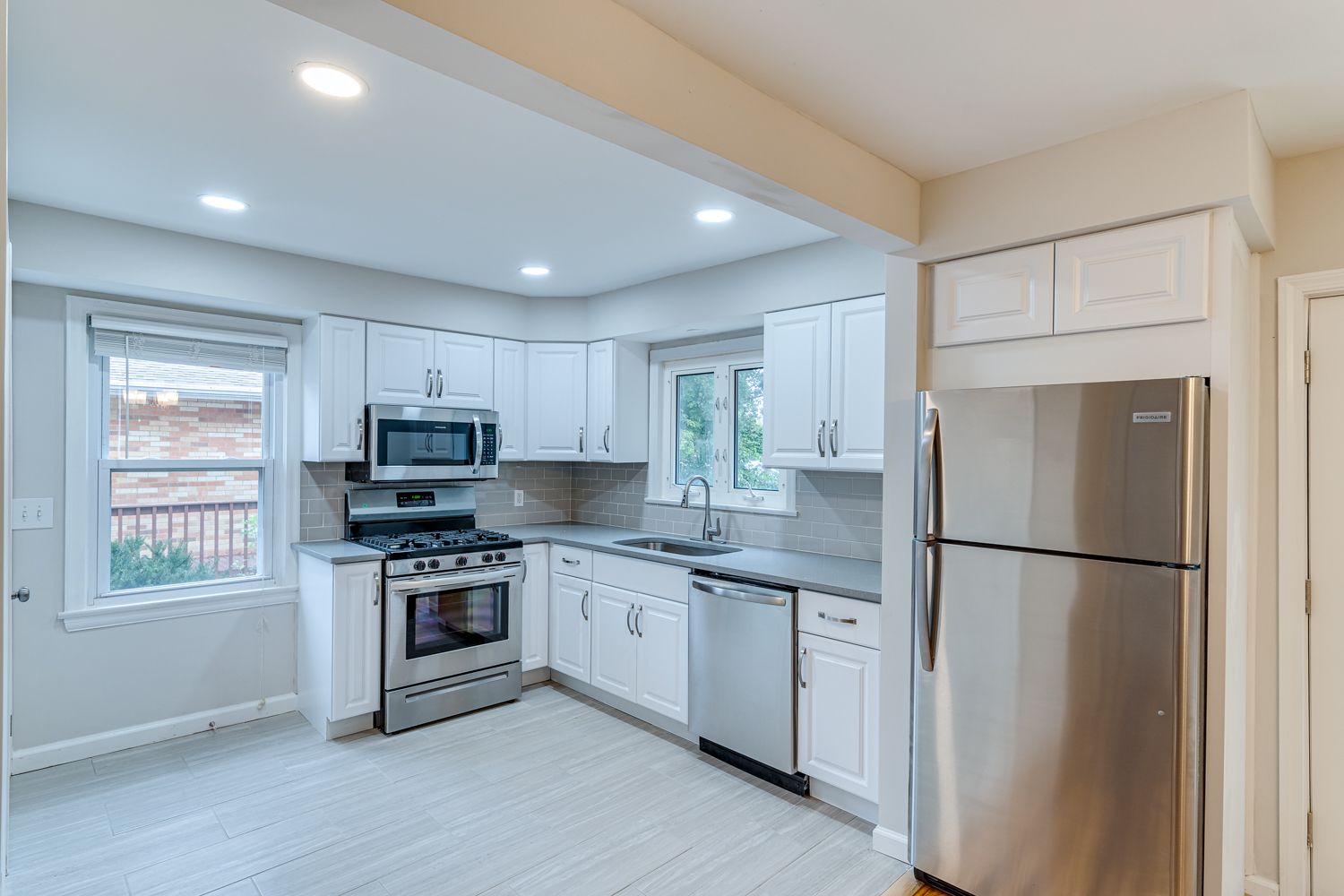 Renovated kitchen with white cabinetry and stainless steel appliances