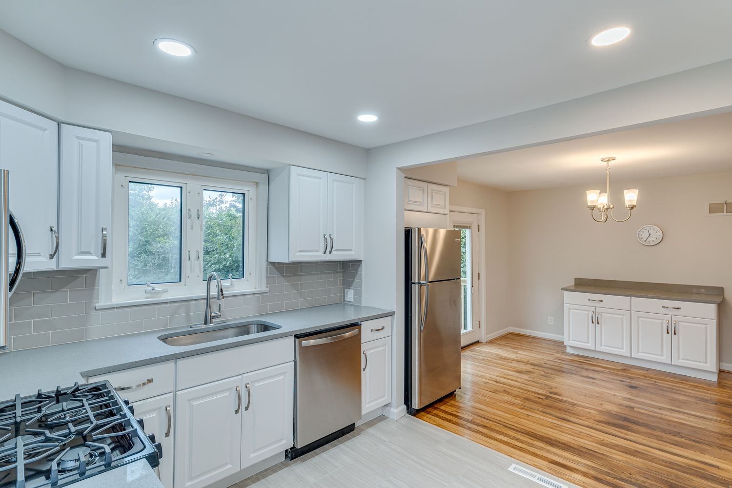 Open kitchen overlooking dining room with refinished hardwood floors