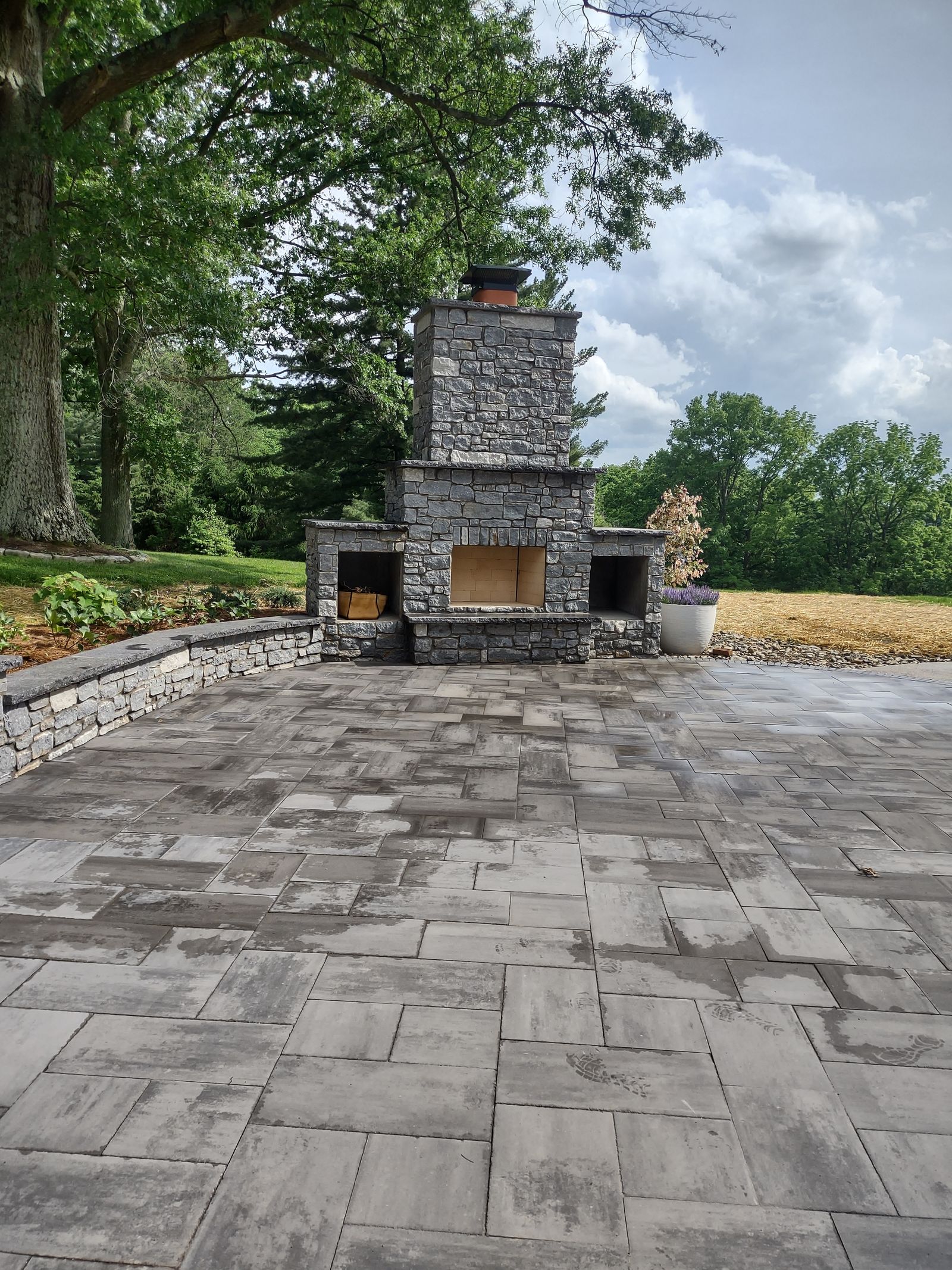Paver patio stonework leading up to an outdoor fireplace