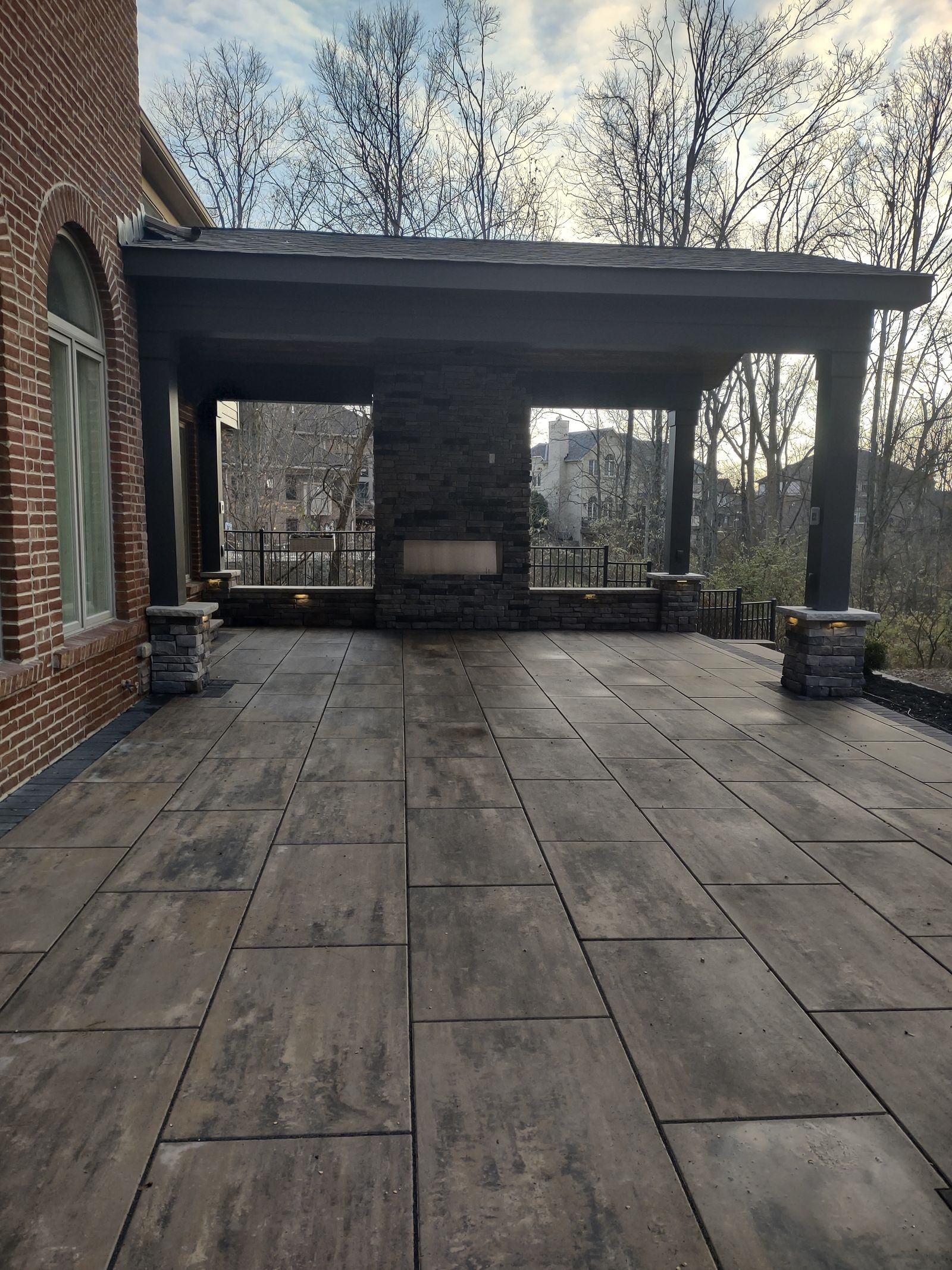 Flat-roof pavilion with stone fireplace and paver floor