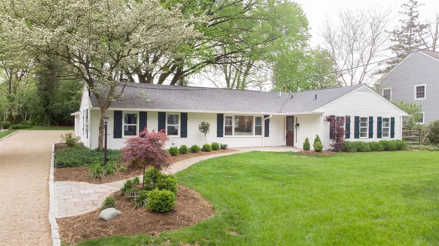 Renovated ranch front exterior with lawn and mature trees