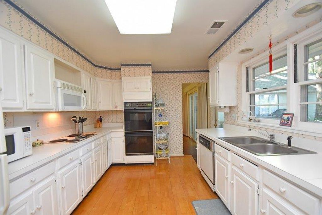 Enclosed galley kitchen with wall oven before renovation