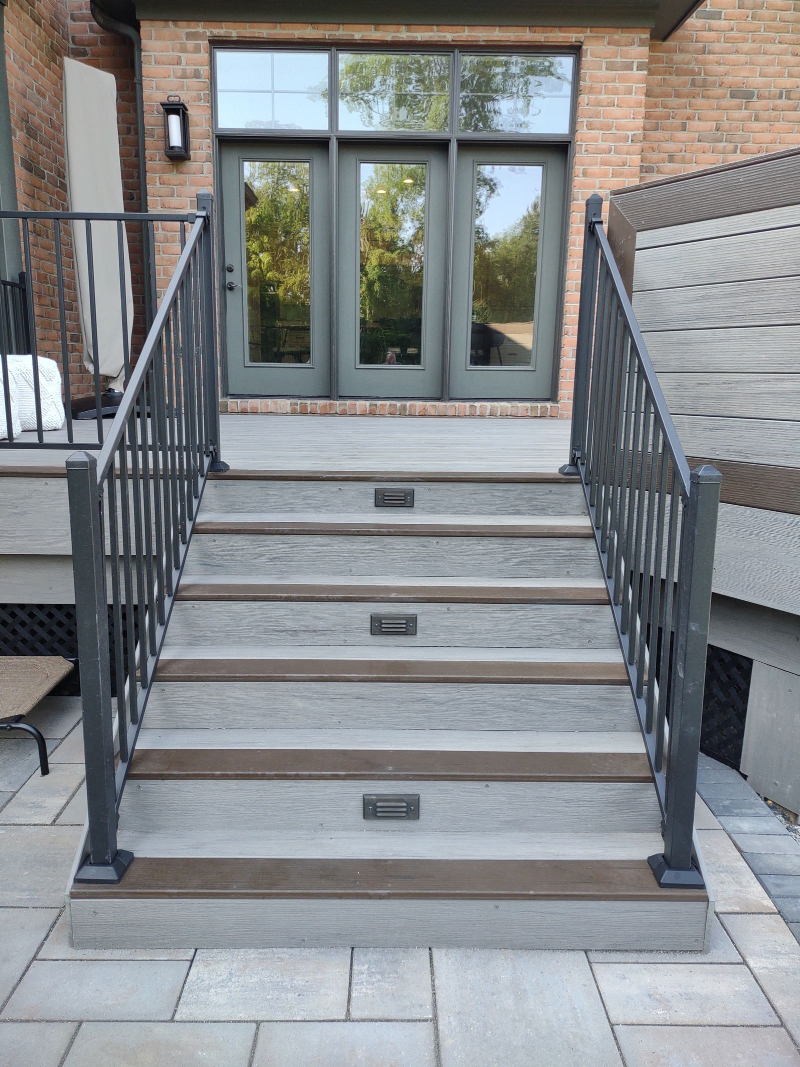 Stone outdoor fireplace beside a multi-level timber deck