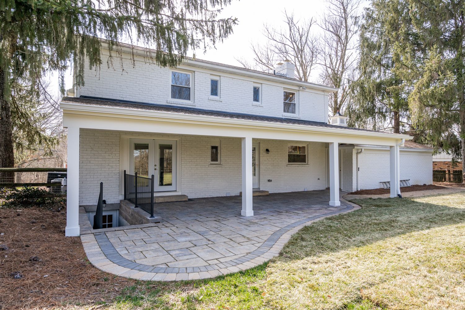 Covered rear patio with columns and curved paver terrace